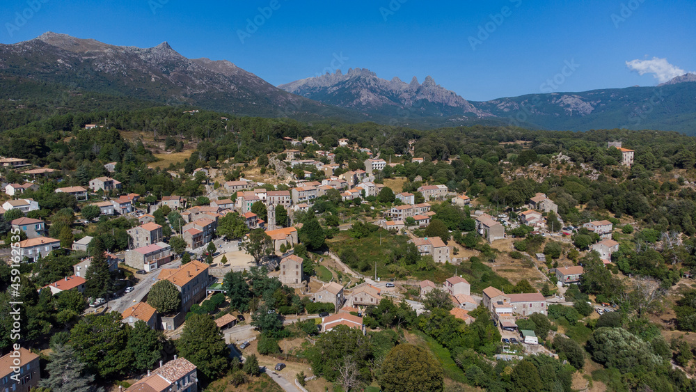Aerial view of the mountainous village of Quenza in the Alta Rocca region of the South of Corsica, France - Stone buildings in front of the famous Bavella Peaks