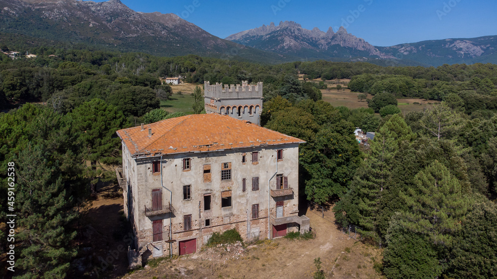 Aerial view of the mountainous village of Quenza in the Alta Rocca region of the South of Corsica, France - Abandoned castle in front of the famous Bavella Peaks