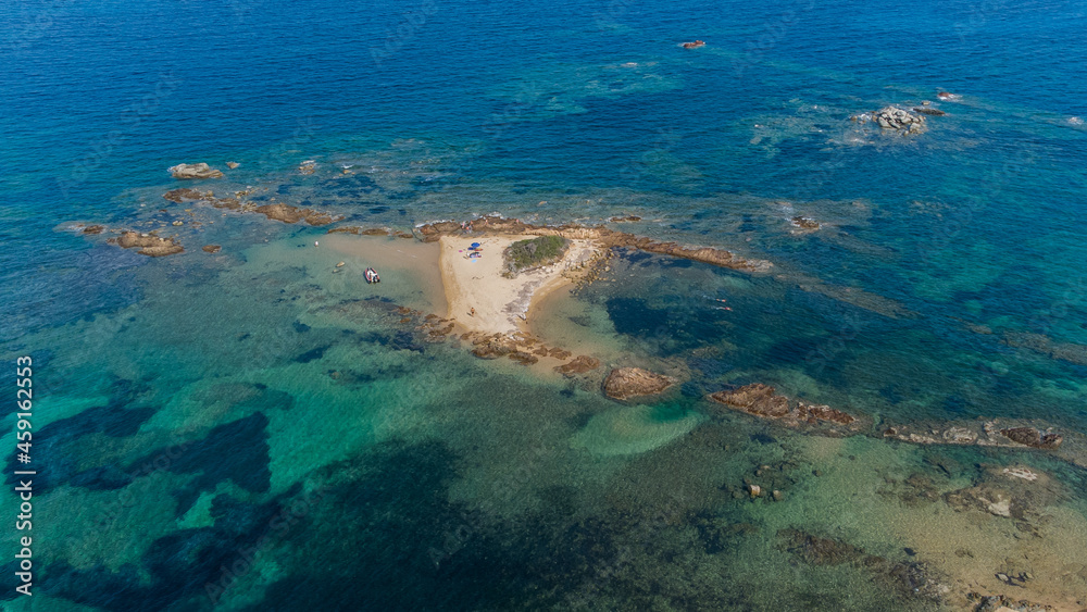 Aerial view of an isolated sandy islet in the bay of Saint Cyprien in the South of Corsica, France - Small group of tourists enjoying their own private island offered by nature