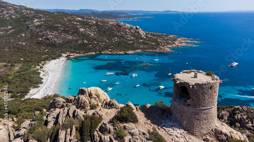 Aerial view of the ruins of the Genoese tower of Roccapina in the South of Corsica, France - Rounded tower overlooking the bay and beach of Roccapina with turquoise waters in the Mediterranean Sea