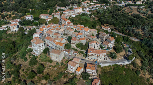 Aerial view of the village of Sainte Lucie de Tallano in the mountains of Southern Corsica, France - Round shaped medieval village with old houses surrounded by pine forests © Alexandre ROSA