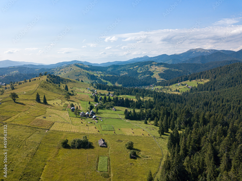 Green mountains of the Ukrainian Carpathians on a sunny summer morning. Coniferous trees on the mountain slopes and green grass. Aerial drone view. Green mountains of the Ukrainian Carpathians on a sunny summer morning. Coniferous trees on the mountain slopes and green grass. Aerial drone view.