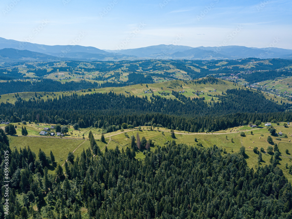Green mountains of the Ukrainian Carpathians on a sunny summer morning. Coniferous trees on the mountain slopes and green grass. Aerial drone view. Green mountains of the Ukrainian Carpathians on a sunny summer morning. Coniferous trees on the mountain slopes and green grass. Aerial drone view.