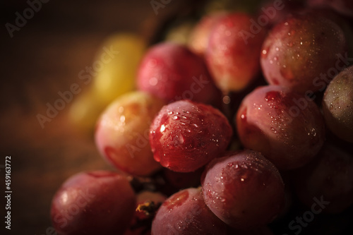 Fresh red and green organic grapes on wooden table, selective focus