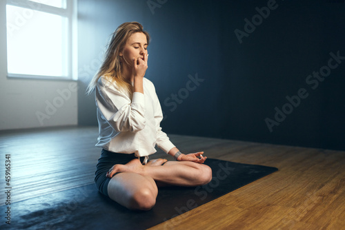 Woman doing anulom vilom. Yoga practice in the studio. photo