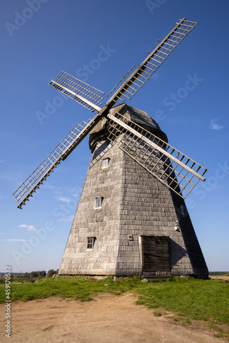 Old wooden wind mill in Lazdininkai village, Darbėnai, Lithuania on a sunny day. Old traditional Dutch mill. 