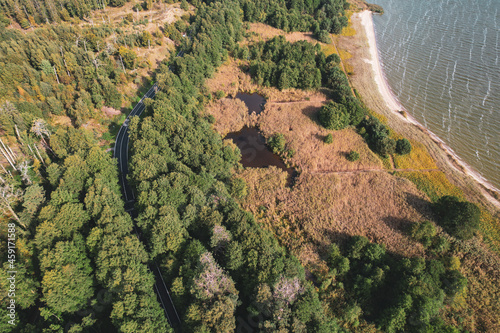 Aerial view with dunes, forest and sea in Curonian spit on a sunny day photographed with a drone. The Curonian Spit lagoon is a Unesco world heritage site. Gray Dunes, Dead Dunes.  photo