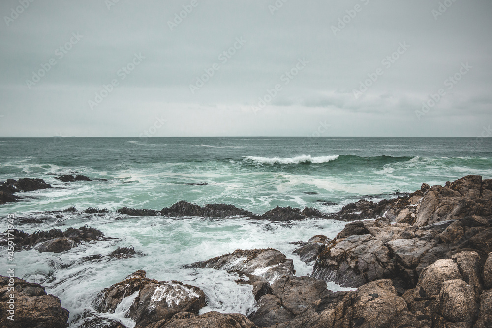 Waves hitting the rocks on a dark beach