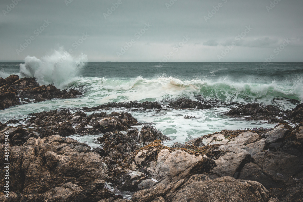 Waves crashing the rocks on a dark beach
