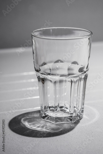 Sturdy looking empty glass tumbler on a white table.
