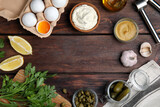 Tasty tartar sauce and ingredients on wooden table, flat lay. Space for text