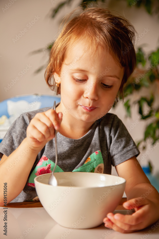 Child and baby food concept. Beautiful little child girl eats milk breakfast. Child and baby food concept. Beautiful little child girl eats milk breakfast.