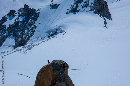 Mountain landscape with alpinist climbing Aiguille du Midi at 3842m, Mont Blanc massif , French Alps, Chamonix, Haute Savoie region, France