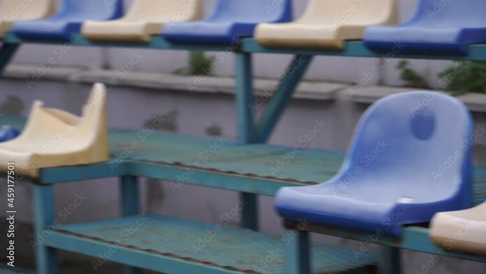 Empty spectator stands at the sports stadium. Plastic seats in blue and white without fans Empty spectator stands at the sports stadium. Plastic seats in blue and white without fans