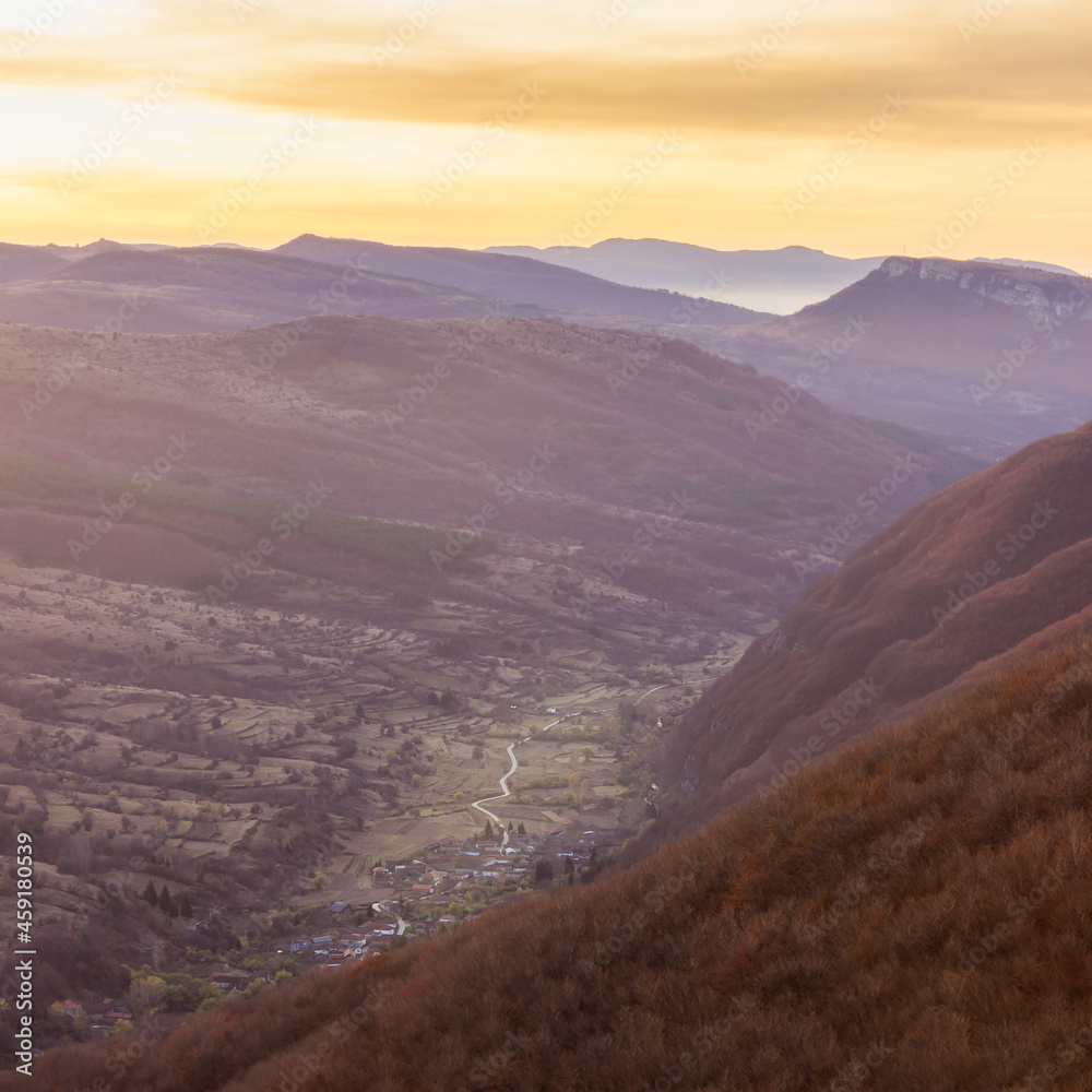 Perfect autumn sunrise above the valley of Dojkinci village and distant horizon mountains