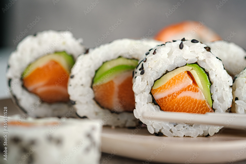 A set of fresh sushi rolls with salmon, avocado and black sesame seeds  close up. California roll, selective focus Stock Photo | Adobe Stock