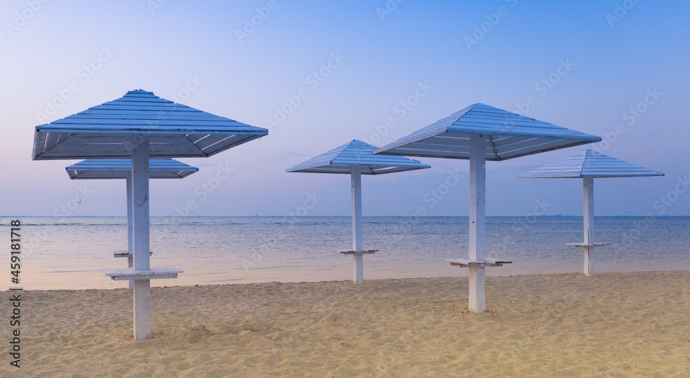 clean beach with wooden umbrellas, And the blue evening sky