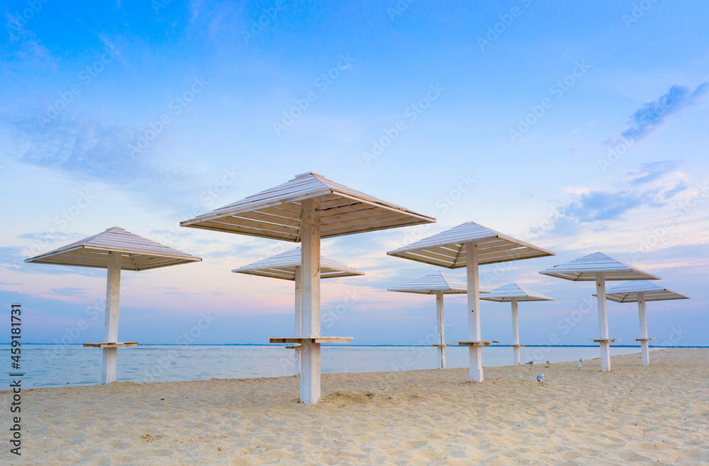 clean beach with wooden umbrellas, And the blue evening sky