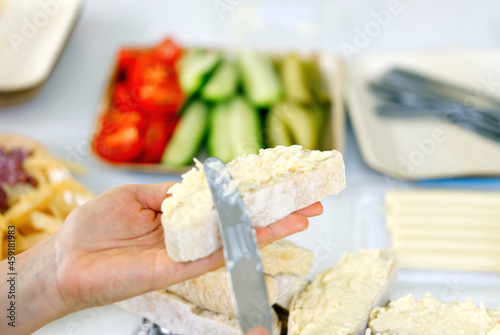 woman hand spreads bread with cheese salad with garlic. the process of preparing a snack for a grill party photo