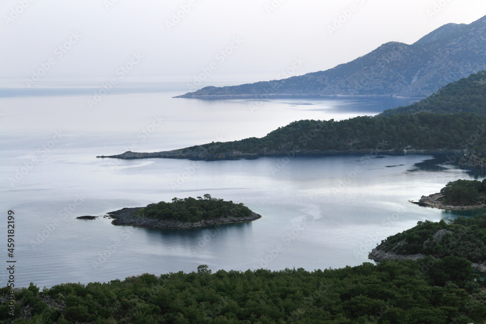 calm blue sea with an island and peninsula in the evening