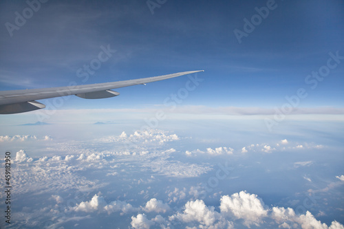 Wing of the plane on blue sky background. Aerial view of Blue sky and Cloud Top view from airplane window,Nature background. Sky and clouds. airplane wing