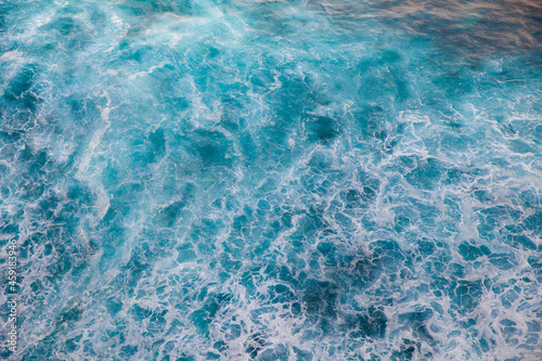 Deep blue stormy sea water surface with white foam and waves pattern, background photo texture