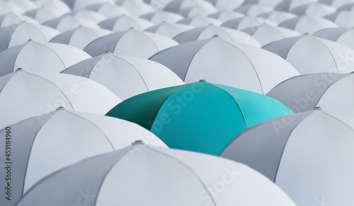 Turquoise umbrella standing out of other ones