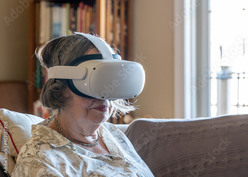 Εκτύπωση καμβά Senior lady seated at home and watching a movie or a quest app on a modern virtu