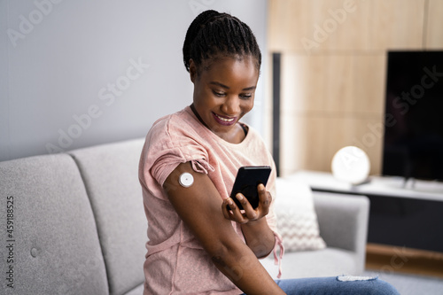 Woman Testing Glucose Level With Continuous Glucose Monitor photo