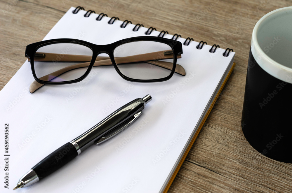 pen and glasses on notebook pen and glasses on notebook
