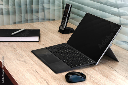 laptop on desk with a book