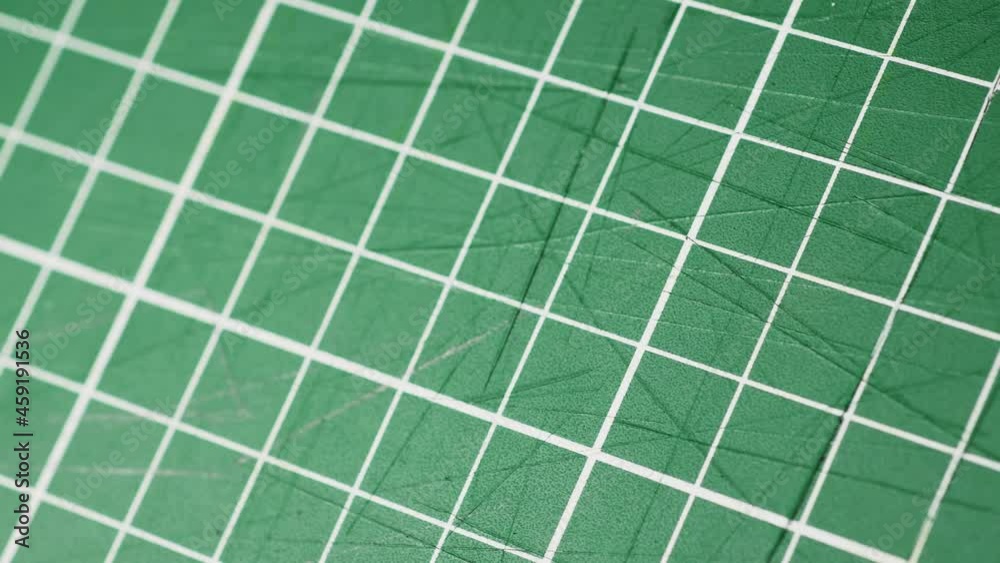 Cutting mat close up, regular grid in centimeters used to cut with scissors or scalpel. Can be used to represent measurement or a blueprint, used by modeling, architecture, engineering and students. Cutting mat close up, regular grid in centimeters used to cut with scissors or scalpel. Can be used to represent measurement or a blueprint, used by modeling, architecture, engineering and students.
