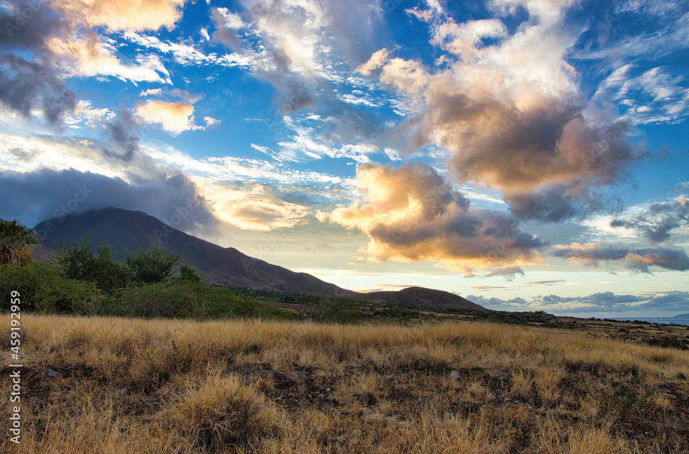 Sunrise over the west maui mountains featuring dramatic clouds and sky.
