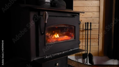 A wood burning stove seen burning wood in a family home to keep the house warm during the winter photo