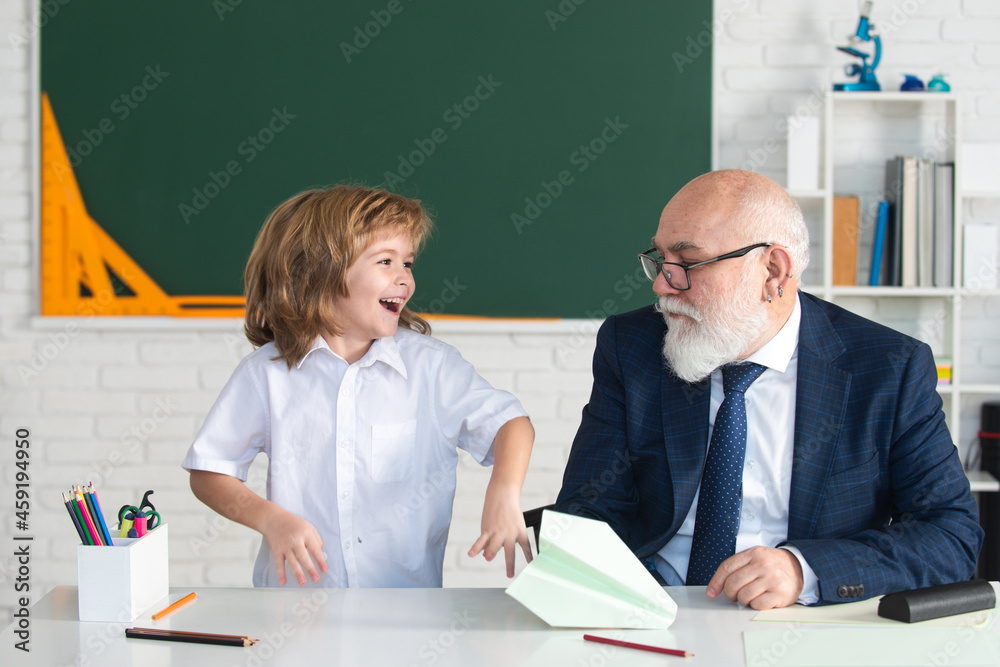 Old senior teacher and school boy pupil. Education in elementary school, kids learning concept. Old senior teacher and school boy pupil. Education in elementary school, kids learning concept.