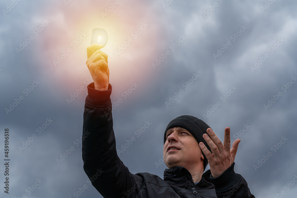 A man on a cold cloudy autumn day holding a vitamin D emitting sunshine