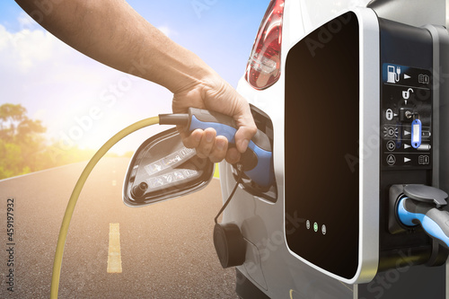 Charging an electric car on road with station for clean energy future of transportation