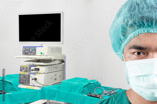 Close up image half face of surgeon looking at camera and equipment tools in operating room