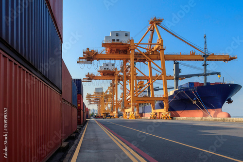 Container loading in a cargo freight ship with ports crane bridge loading export containers box in import and export business logistic industry and transportation concept.