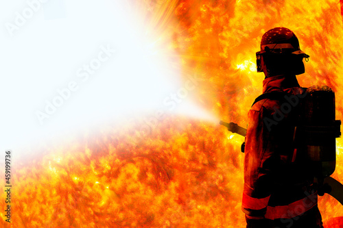 Fototapeta Naklejka Na Ścianę i Meble -  Silhouette of Firemen fighting a raging fire with huge flames of burning with work space  Elements of this image are furnished by NASA