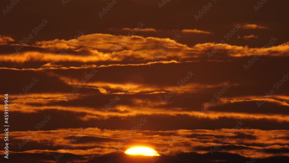 4k fast speed closeup scene by super telephoto lens on big orange color sun rise up pass through stream of dark cloud on cloudy sky, mysterious beautiful nature view of cloudscape in the morning 4k fast speed closeup scene by super telephoto lens on big orange color sun rise up pass through stream of dark cloud on cloudy sky, mysterious beautiful nature view of cloudscape in the morning