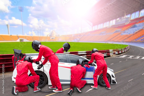  Pit stop with team maintaining technical service for a racing car during competition © thanapun