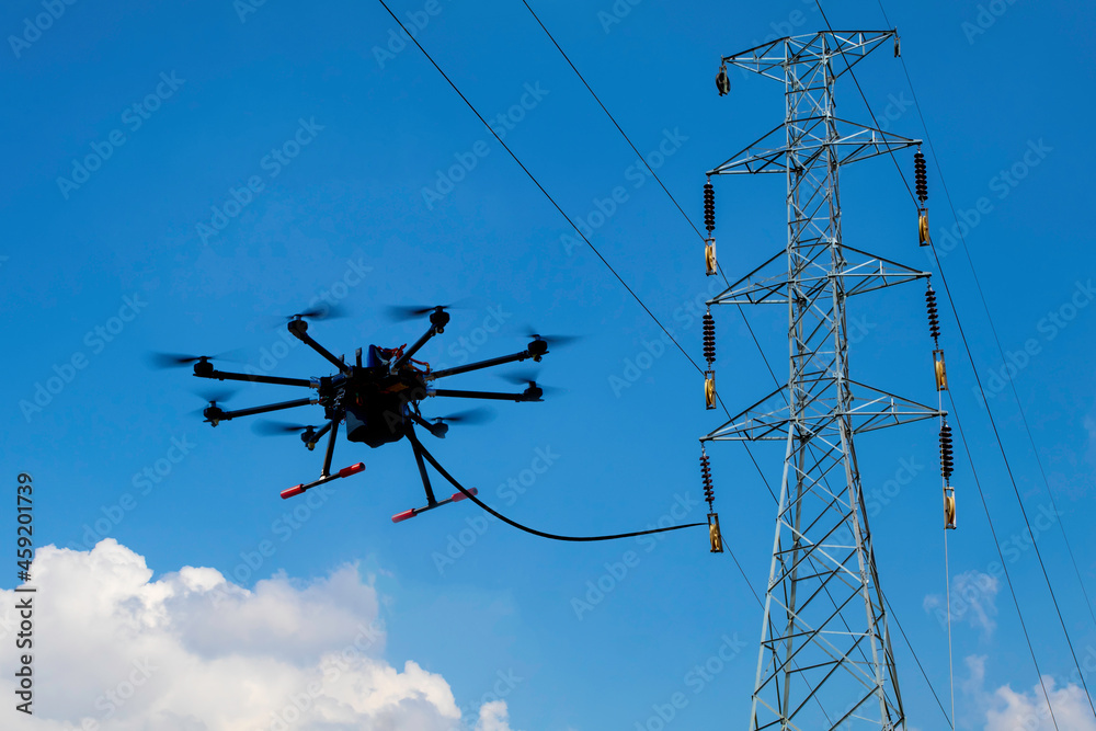 Drone stringing transmission lines of electrical high power. stringing