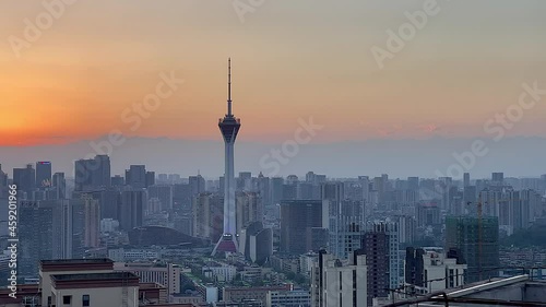 Aerial shot, panning across sunset over Chengdu city skyline with the Jinxiu Tianfu Television Tower and vast city landscape photo