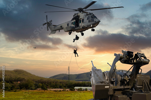 Anti Aircraft gun with military commando helicopter drops between are in flight for operation battle combat
