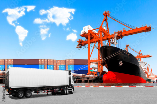 Truck container commercial delivery cargo and container ship being unloaded at the harbor with clouds in shape of world map concept for transportation around the world