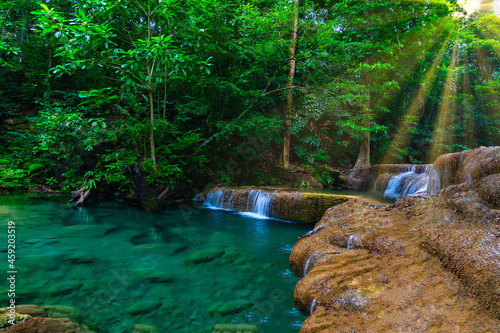 Fototapeta Naklejka Na Ścianę i Meble -  Erawan waterfall in the tropical jungle surrounded by a natural with turquoise clear fresh water and green forest on mountain in kanchanaburi, thailand.