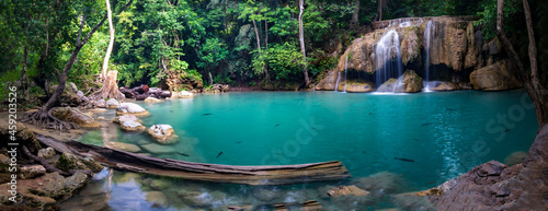 Panorama photo of erawan waterfall in the tropical jungle surrounded by a natural with turquoise clear fresh water and green forest in kanchanaburi, thailand. photo