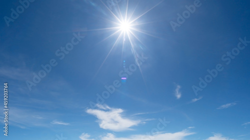 Shining sun on clear blue sky with lens flare of sunlight on sky background Bright sun on blue sky Concept Nature and environment background