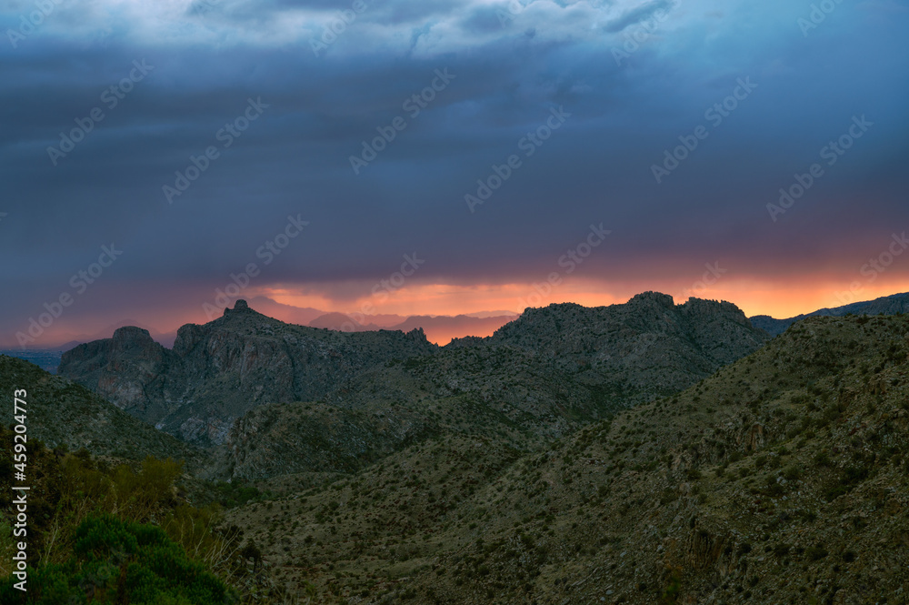 Dramatic sunset sky with monsoon rain over Thimble Peak in Tucson